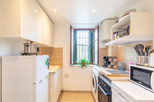  La cuisine est équipée de placards blancs et d'un réfrigérateur. dans l'établissement La Suquétane - Appt proche plage Cannes, à Cannes