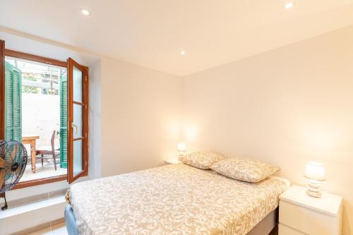 une chambre avec un lit et une fenêtre dans l'établissement La Suquétane - Appt proche plage Cannes, à Cannes