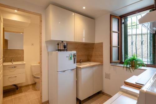 une cuisine avec un réfrigérateur blanc et un évier dans l'établissement La Suquétane - Appt proche plage Cannes, à Cannes