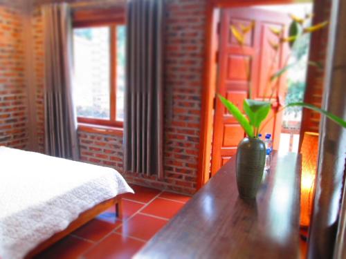 a wooden table with a vase with a plant on it at Ninh Binh Nature Homestay in Ninh Binh