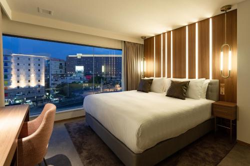 una camera da letto con un letto grande e una grande finestra di The OneFive Villa Fukuoka - Vacation STAY 33467v a Fukuoka
