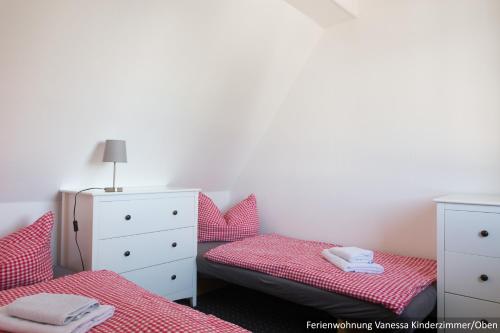 a bedroom with two twin beds and a dresser at Ferienwohnung in Bodden & Ostsee nähe in Sagard