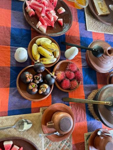 a table with plates of fruit and bowls of food at Kandy Food Lovers Home Stay by AGS in Kandy
