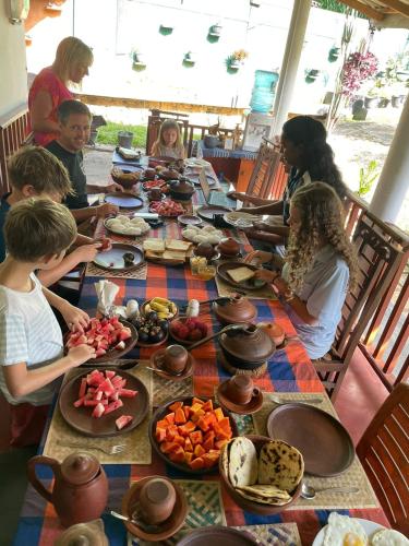 a group of people sitting around a long table with food at Kandy Food Lovers Home Stay by AGS in Kandy
