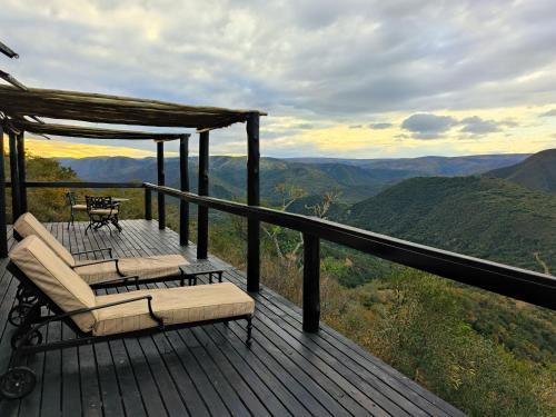 a deck with chairs and a table and a view at Camp Figtree by The Oyster Collection in Addo