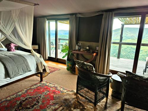 a bedroom with a bed and a desk and a window at Camp Figtree by The Oyster Collection in Addo