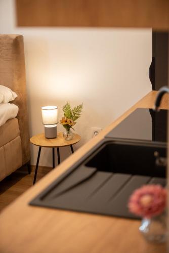 a kitchen with a sink and a table with a candle at Emerald Residence Apartments in Dunajská Streda