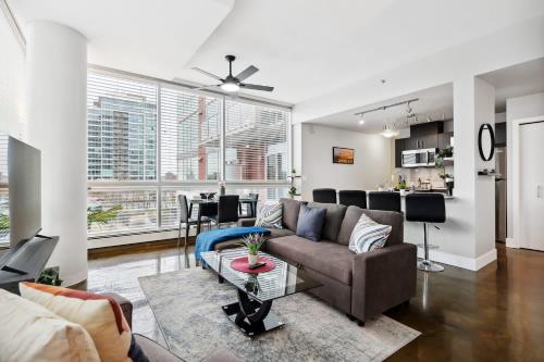 a living room with a couch and a table at Modern Condo w Balcony - Steps from Stampede Park in Calgary