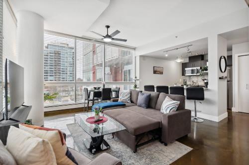 a living room with a couch and a table at Modern Condo w Balcony - Steps from Stampede Park in Calgary
