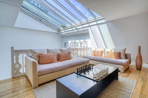 - un salon avec un canapé et un échiquier dans l'établissement Sweett - Maison Wagram, à Paris