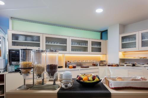 una cocina con una barra con un bol de fruta. en Steris Elegant Beach Hotel, en Rethymno