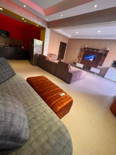 a living room with a couch and a tv at Garden Apartment in Sheikh Zayed Private Entrance 24h Security in Sheikh Zayed