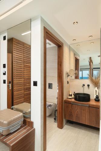 a bathroom with a sink and a toilet and a tub at Elia Sea Suites in Chania Town