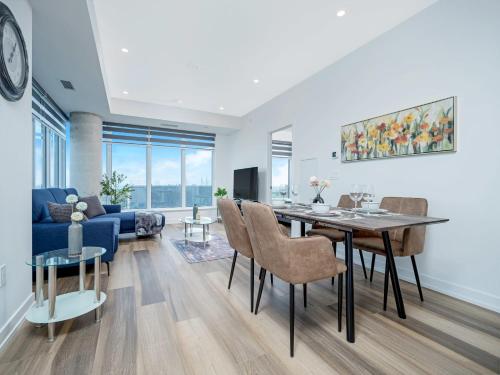 a living room with a table and a blue couch at City View 1BR Condo - King Bed & Private Balcony in Kitchener