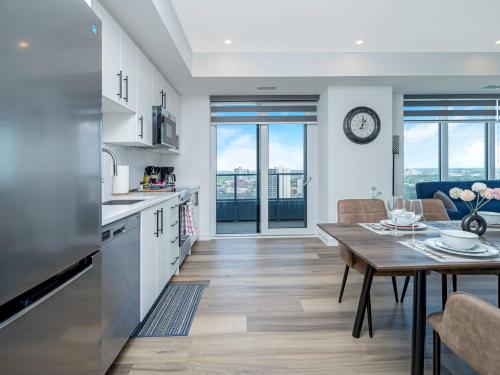 a kitchen and living room with a table and a dining room at City View 1BR Condo - King Bed & Private Balcony in Kitchener