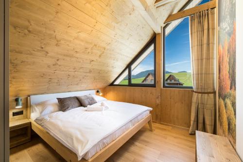 a bed in a room with a large window at Liptovské Chaty in Liptovský Mikuláš