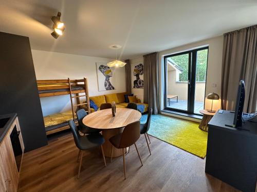 a living room with a table and a bedroom at Angel Wings Mountain Apartment Černý Důl in Cerny Dul