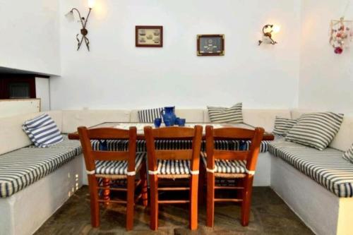a dining room with a table and chairs and a couch at Aegean View Maisonnette in Neos Marmaras