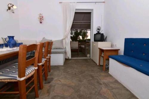 a living room with a blue couch and chairs at Aegean View Maisonnette in Neos Marmaras
