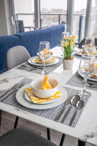 a white table with plates of food and wine glasses at 1BR Modern Condo - King Bed and Stunning City View in Kitchener