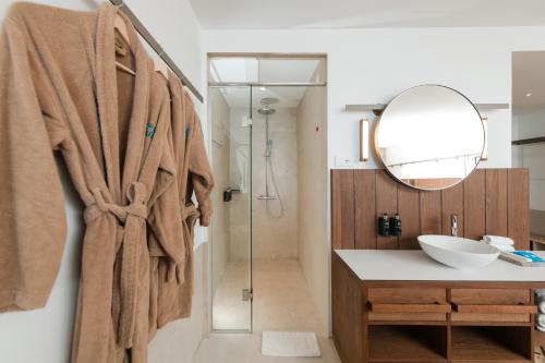 a bathroom with a shower and a sink and a mirror at Folie Marine Hotel & Beach Club in Jal