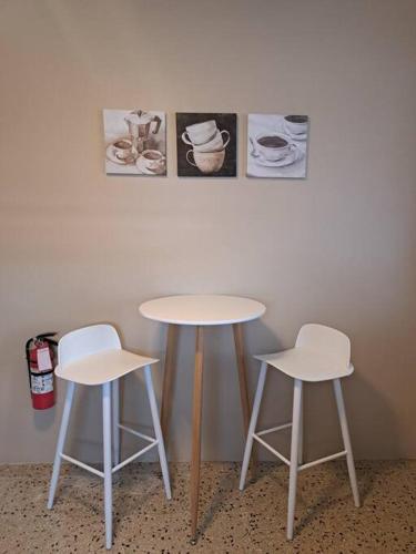 two tables and two stools next to a wall at Cómodo y acogedor en Fajardo con vista al mar in Fajardo