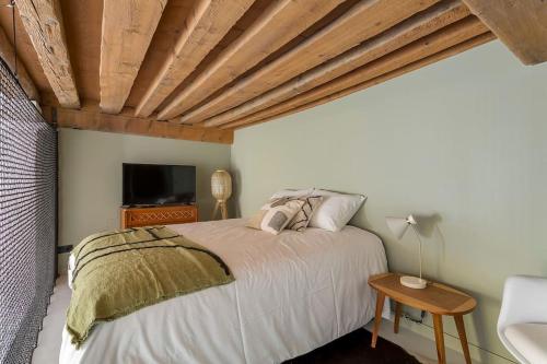 une chambre avec un lit avec un plafond en bois dans l'établissement L'Eugénie, secteur Opéra et climatisé, Lyon 1er, à Lyon