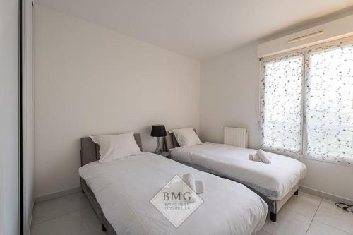 deux lits jumeaux dans une chambre avec fenêtre dans l'établissement Danube appartement Disneyland, à Serris