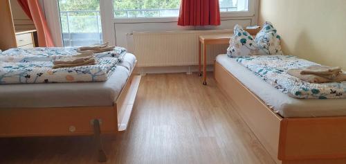 a small room with two beds and a window at Herzerl Apartment in Sankt Englmar