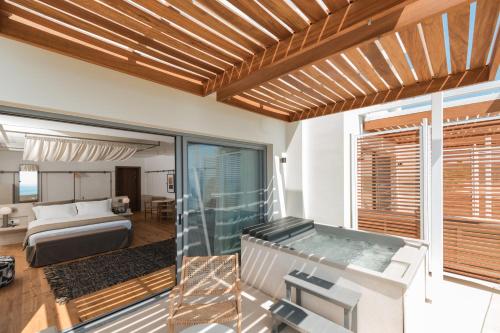 a room with a jacuzzi tub and a bedroom at Folie Marine Hotel & Beach Club in Jal