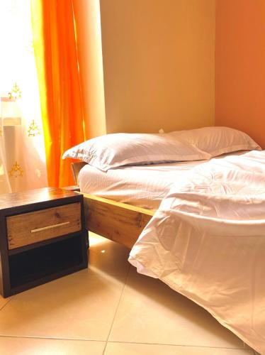 two twin beds in a room with a table and a window at Bethh serviced Apartments in Ruiru
