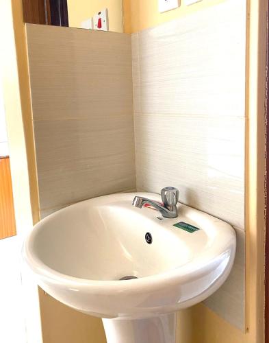 a white sink in a small bathroom at Bethh serviced Apartments in Ruiru
