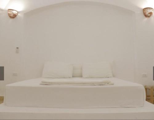 a white bed with two lights on top of it at Aqua Sun in Nuweiba