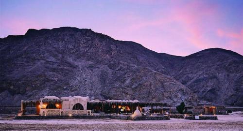 a building with lights in front of a mountain at Aqua Sun in Nuweiba