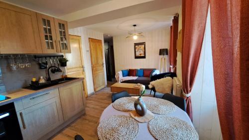Il comprend une cuisine et un salon avec une table. dans l'établissement T2 bis-Appart2-centre ville, à Châteaubriant