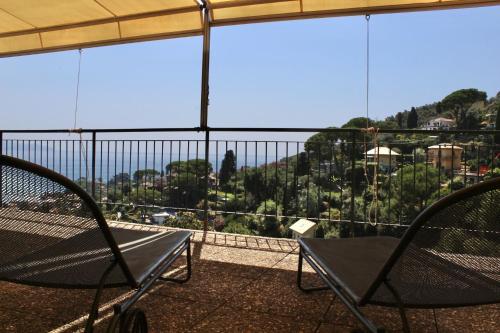 a balcony with two chairs and a view of a city at Hotel Primo Sole in Rapallo
