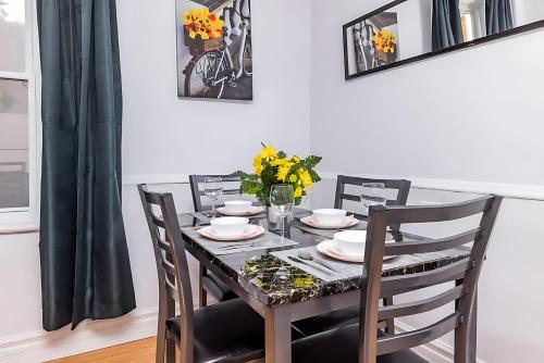 a dining room table and chairs with flowers on it at Pet-friendly Apartment - Steps to Rideau Centre in Ottawa