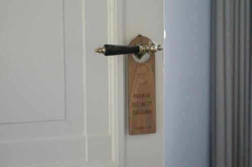 a wooden tag on a door with a door knob at SJ Apartment in Aarhus