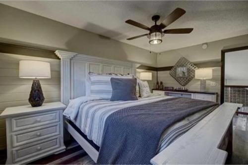 Un dormitorio con una cama con ventilador de techo. en Emmas Rare Find By Beyond Expectations W Hot Tub, en Sevierville