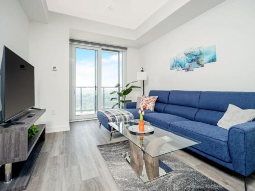 a living room with a blue couch and a tv at Modern 1BR Condo - King bed - Cityscape Views in Kitchener