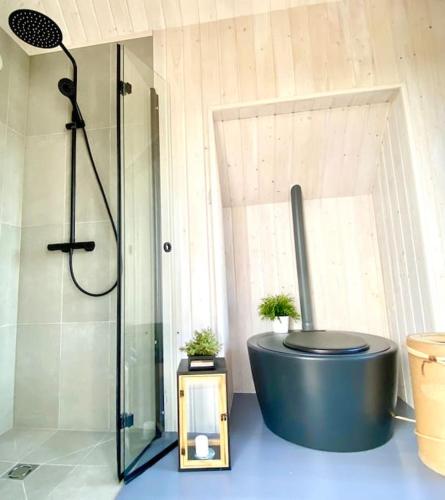 a bathroom with a shower and a bath tub at Japandi Guesthouse in Muhu in Võiküla