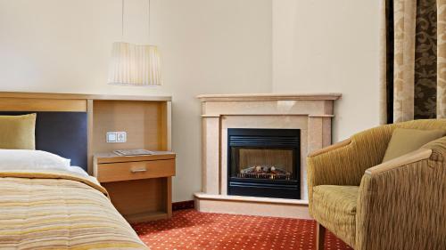a hotel room with a bed and a fireplace at Ambiance Hotel - Braunau - Simbach in Braunau am Inn
