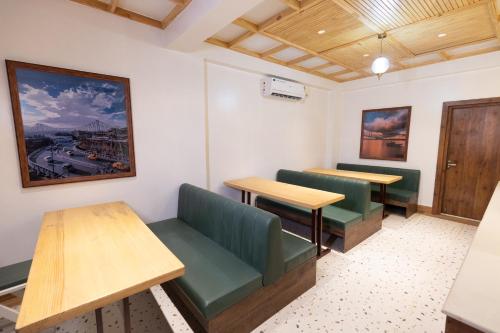 a waiting room with two tables and benches at The Lake Palm Hotel in Kolkata