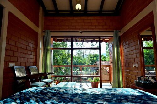 a bedroom with a bed and a large window at Sereno Barn Eco Stay Chikmagalur in Chikmagalūr