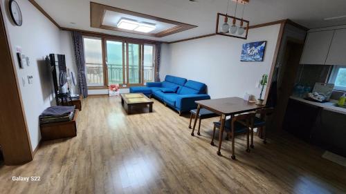 a living room with a blue couch and a table at Geoje Seaside Luxury Family Villa in Geoje 
