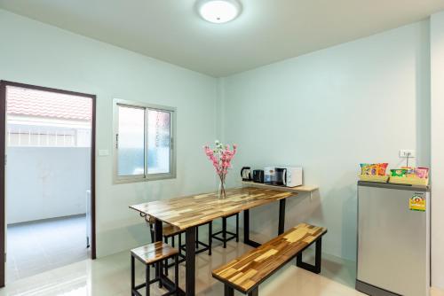 a kitchen with a wooden table and benches in a room at Trisisters Home by Greenway night market in Hat Yai