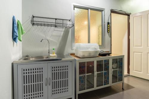 a kitchen with a sink and a window at Trisisters Home by Greenway night market in Hat Yai