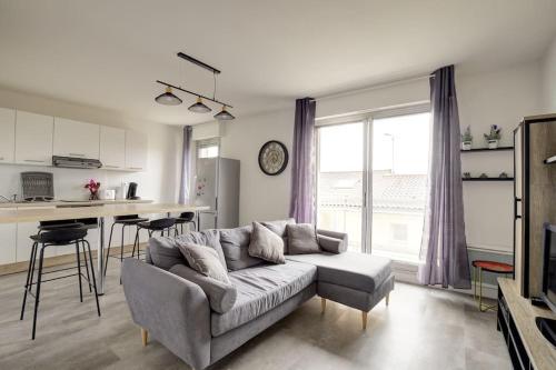 un salon avec un canapé et une cuisine dans l'établissement Appartement 3 chambres avec terrasse et parking, à Albi