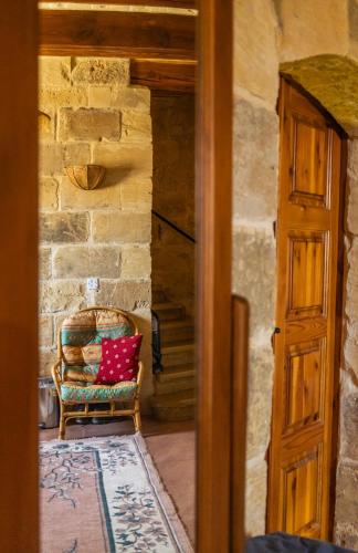 a room with a chair with a red pillow at Serene Country House for Beach and Trekking Lovers in Xagħra