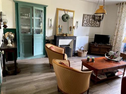 a living room with a table and chairs and a fireplace at Sfeervol huis op het platteland in Mailhac-sur-Benaize